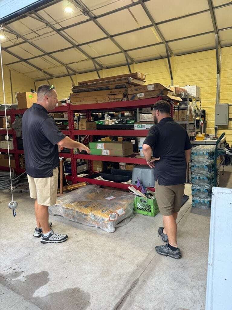 Stockroom with two men discussing electrical supplies for Bryan Hindman Electric.