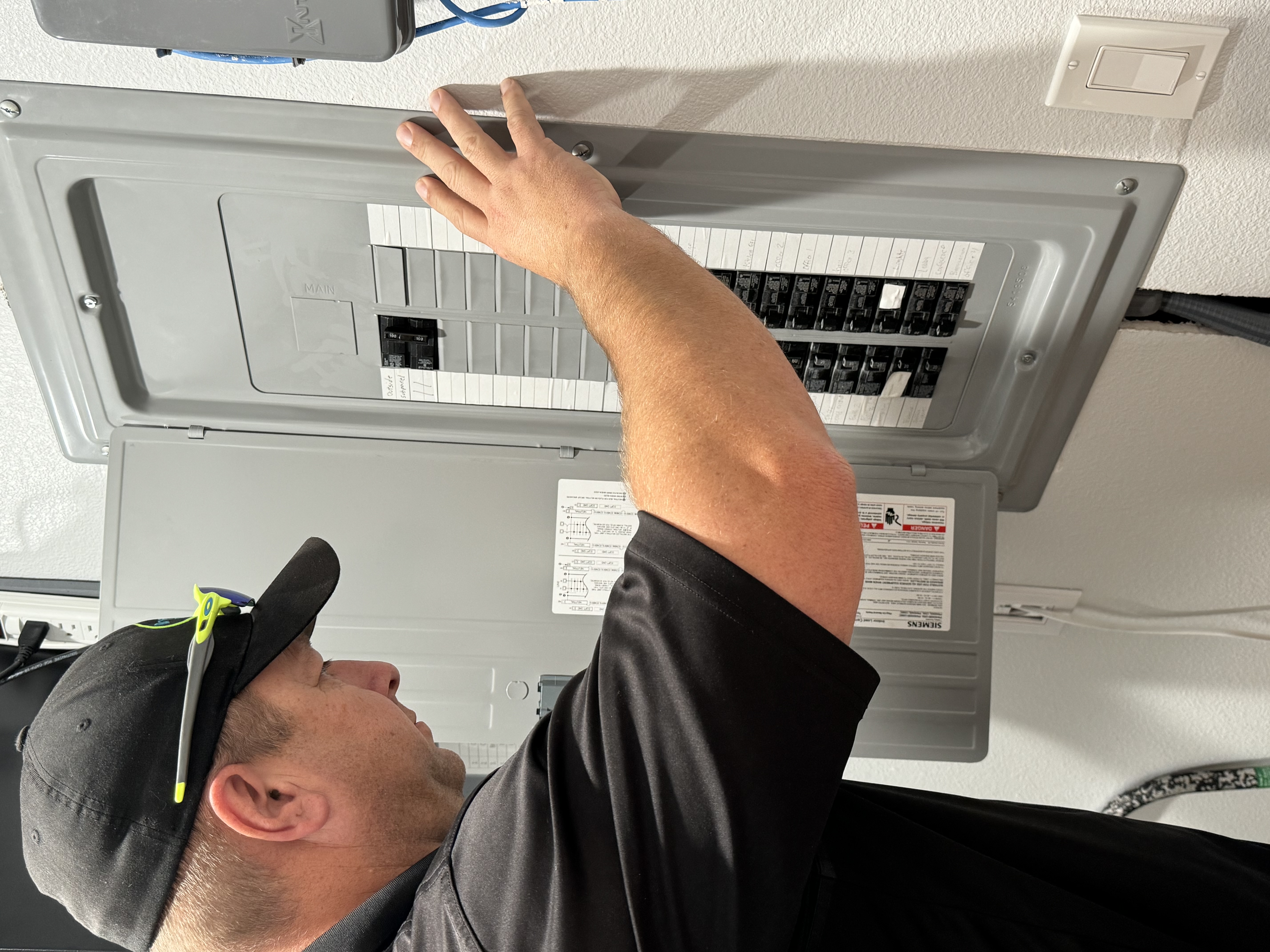 Electrician inspecting electrical panel to determine whether an upgrade is needed.