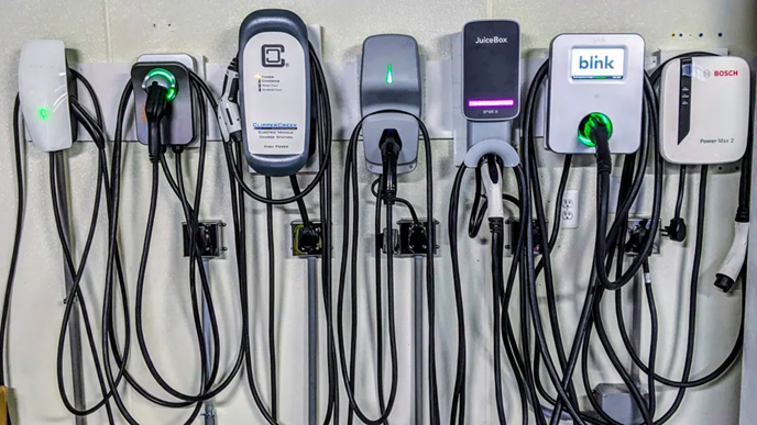 Several different EV chargers against a wall